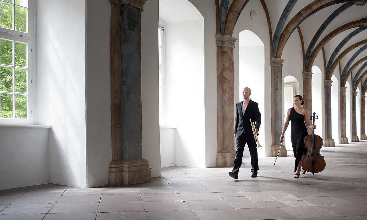 Musiker in historischem Kreuzgang als Symbol für Schlosskonzerte und Festivals in Baden-Württemberg