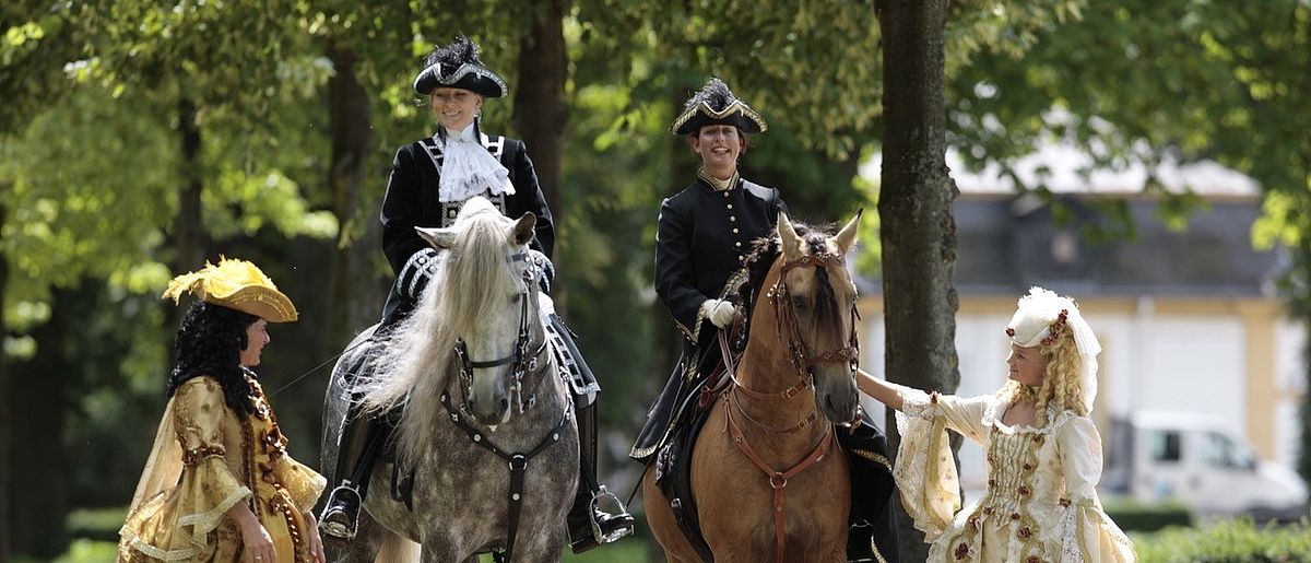 Historische Reitvorführung im Neuhäuser Schlosspark mit Reitern und Pferden bei einer Veranstaltung im historischen Ambiente
